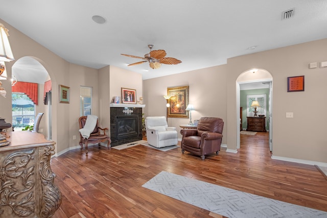 6568 Castlewood St, Navarre, FL 32566 - living room featuring a tiled fireplace, wood-type flooring, and ceiling fan