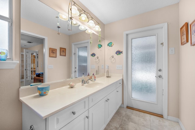 6568 Castlewood St, Navarre, FL 32566 - bathroom with vanity, tile patterned flooring, and a textured ceiling