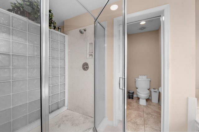6568 Castlewood St, Navarre, FL 32566 - bathroom featuring a shower with door, tile patterned flooring, and toilet