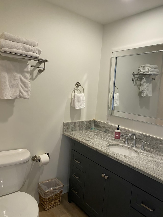 bathroom featuring vanity, hardwood / wood-style flooring, and toilet