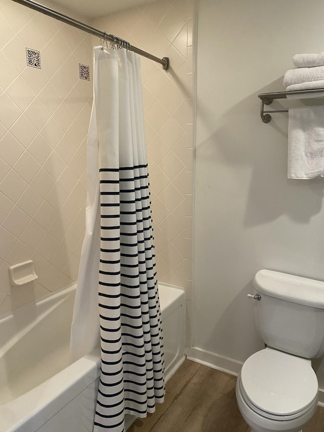 bathroom with hardwood / wood-style flooring, shower / bath combo, and toilet