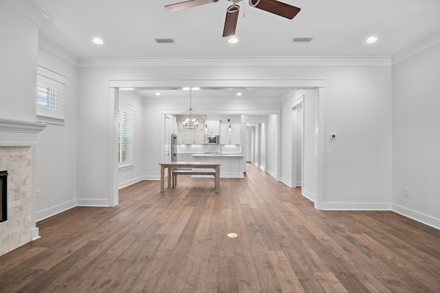 interior space with ornamental molding, a tile fireplace, dark hardwood / wood-style floors, and a healthy amount of sunlight