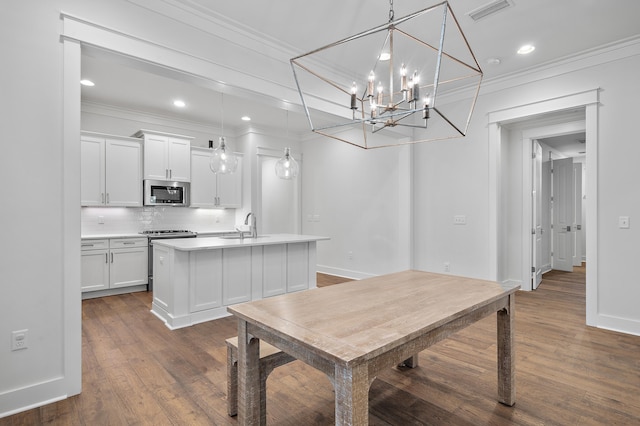 dining area with crown molding, dark hardwood / wood-style flooring, and sink