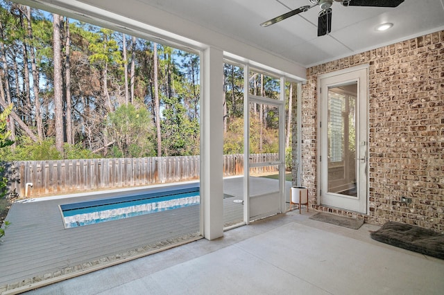 unfurnished sunroom with ceiling fan