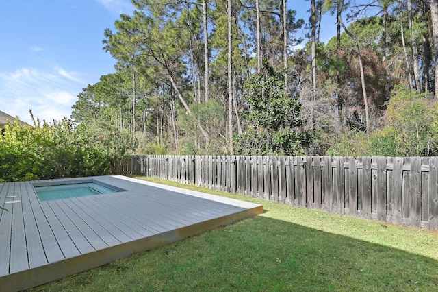 view of swimming pool featuring a wooden deck and a lawn