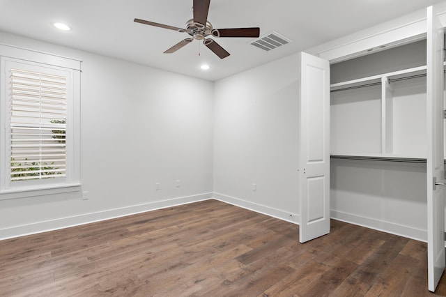 unfurnished bedroom with dark hardwood / wood-style flooring, a closet, and ceiling fan