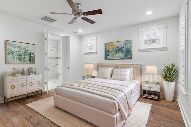 bedroom featuring multiple windows, dark hardwood / wood-style floors, connected bathroom, and ceiling fan