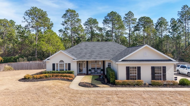 ranch-style house featuring covered porch and a front yard