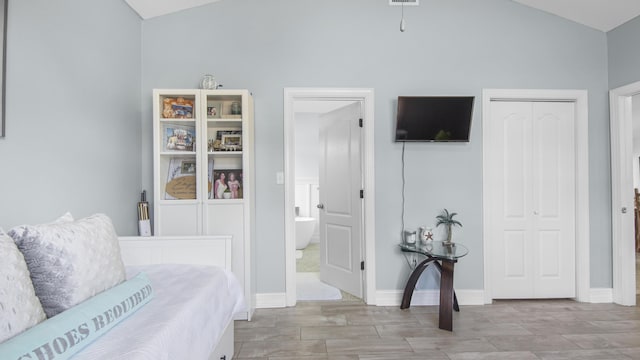 bedroom with lofted ceiling and a closet