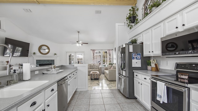 kitchen with light tile patterned flooring, appliances with stainless steel finishes, sink, and white cabinets