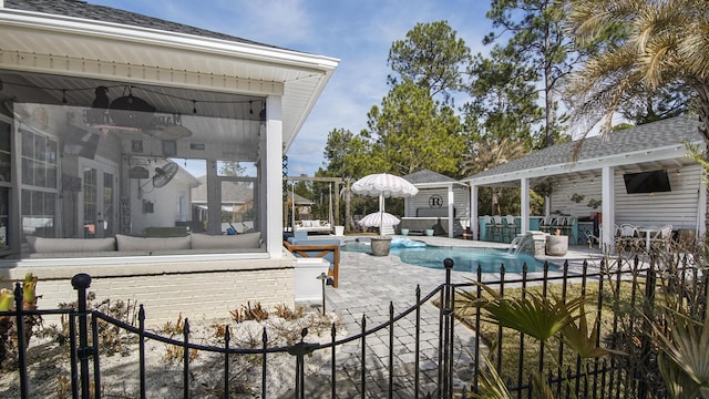 view of pool with an outdoor living space, pool water feature, an outdoor structure, and a patio area