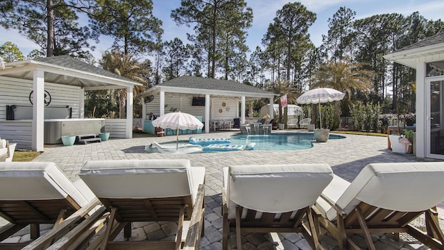 view of swimming pool featuring an outbuilding, pool water feature, a gazebo, and a patio area