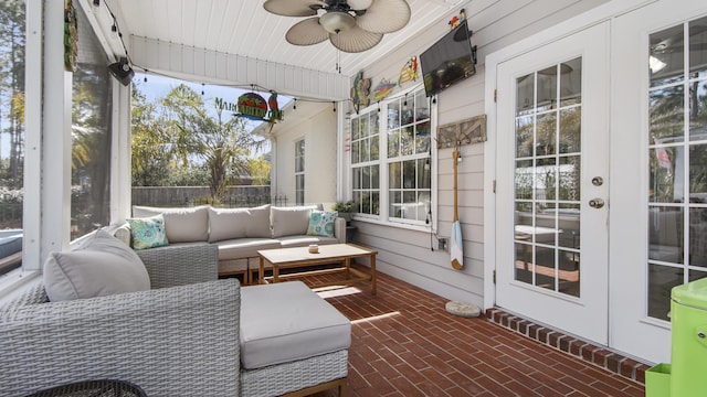 sunroom / solarium featuring ceiling fan and french doors