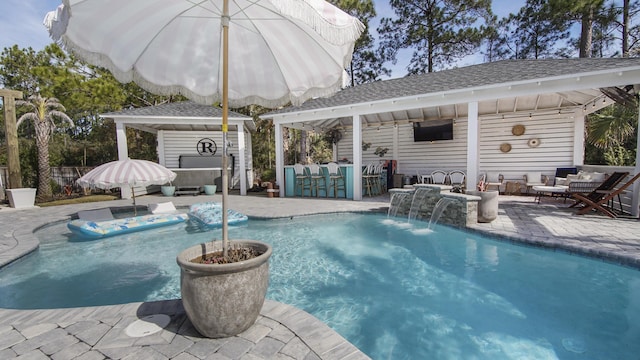 view of pool with exterior bar, pool water feature, an outdoor living space, a gazebo, and a patio area