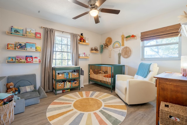 living area featuring light hardwood / wood-style flooring and ceiling fan