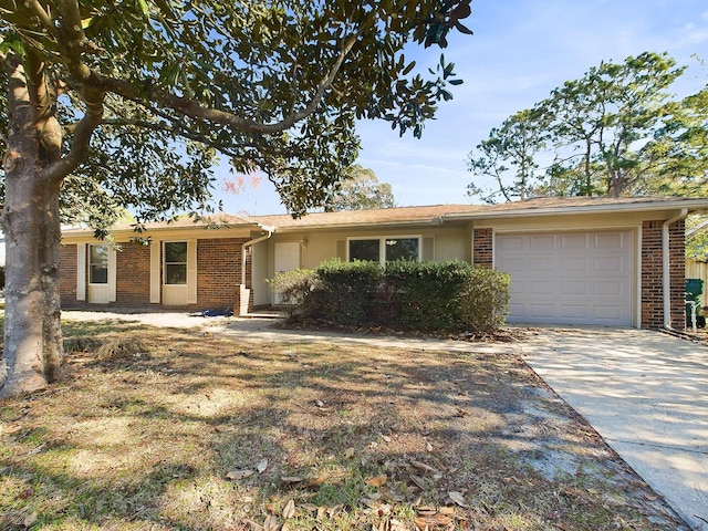 ranch-style house with a garage, concrete driveway, and brick siding