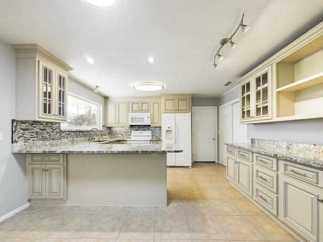 kitchen featuring light stone counters, white appliances, cream cabinetry, and open shelves