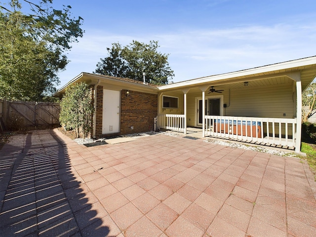 view of patio featuring covered porch, a gate, fence, and a ceiling fan