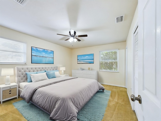 bedroom featuring light colored carpet, visible vents, ceiling fan, and baseboards