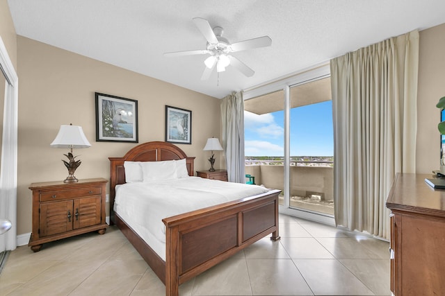 tiled bedroom with access to exterior, expansive windows, a textured ceiling, and ceiling fan