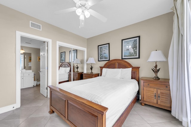 bedroom featuring light tile patterned flooring, ceiling fan, ensuite bath, and a closet