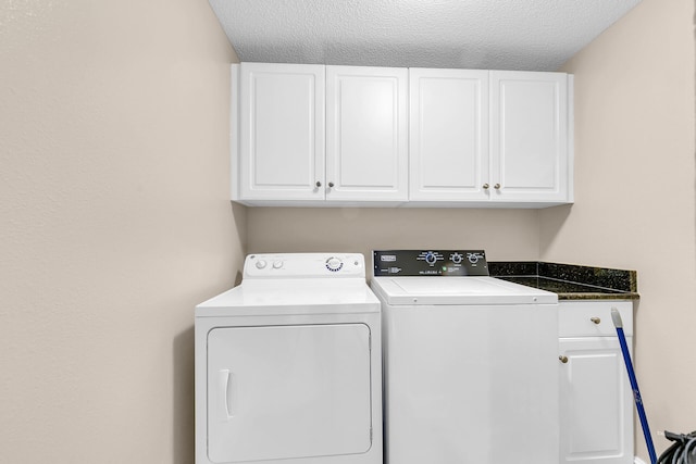 laundry room featuring separate washer and dryer, cabinets, and a textured ceiling