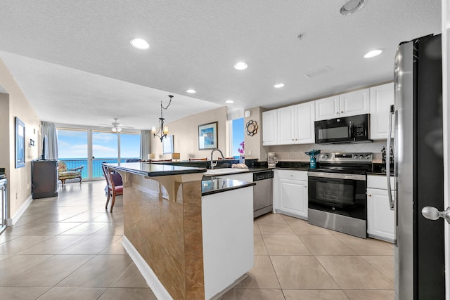 kitchen featuring sink, stainless steel appliances, a water view, white cabinets, and kitchen peninsula