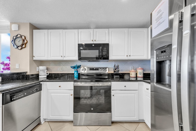 kitchen with appliances with stainless steel finishes, white cabinetry, decorative backsplash, dark stone counters, and light tile patterned floors