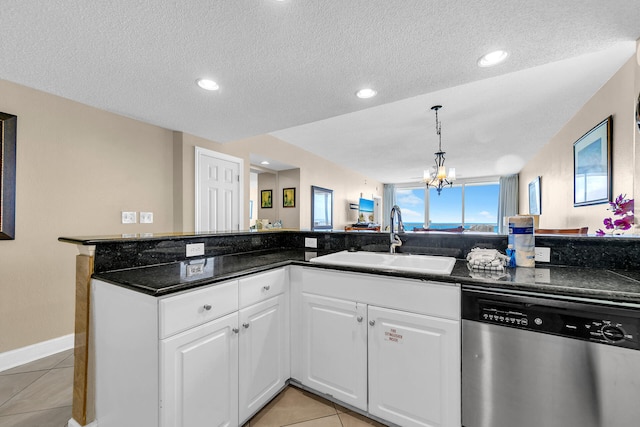 kitchen featuring sink, light tile patterned floors, white cabinetry, stainless steel dishwasher, and kitchen peninsula