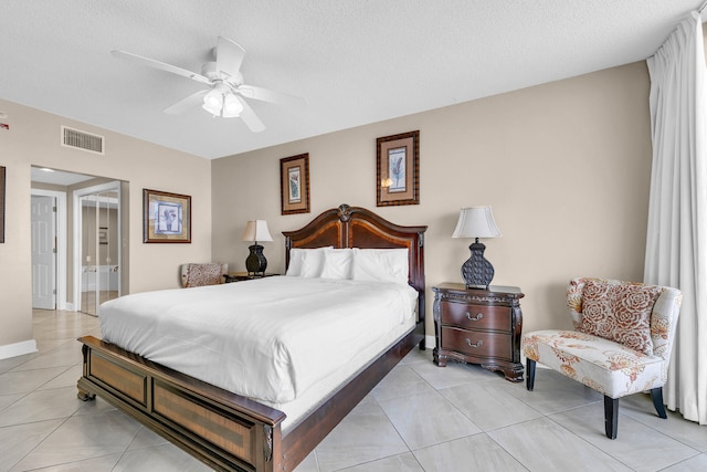 tiled bedroom with ceiling fan, a textured ceiling, and ensuite bathroom