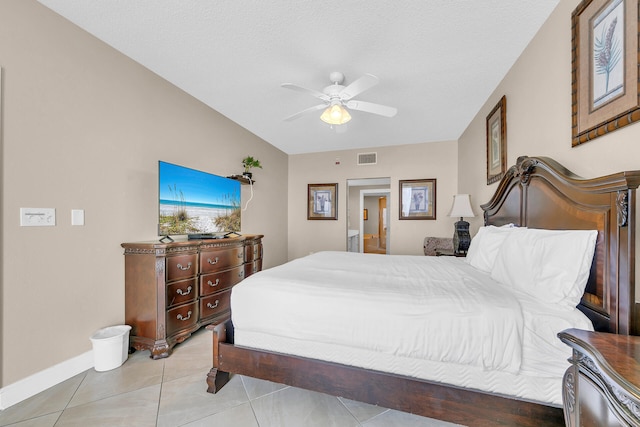 tiled bedroom with ceiling fan and a textured ceiling