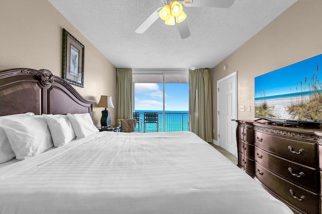 bedroom with ceiling fan, access to exterior, and a textured ceiling