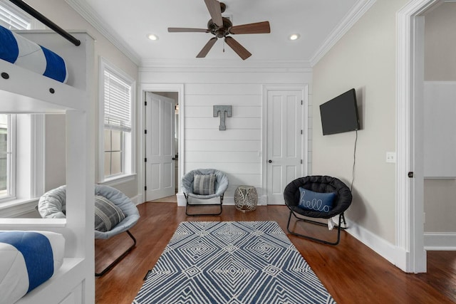 living area with ceiling fan, ornamental molding, and dark hardwood / wood-style floors