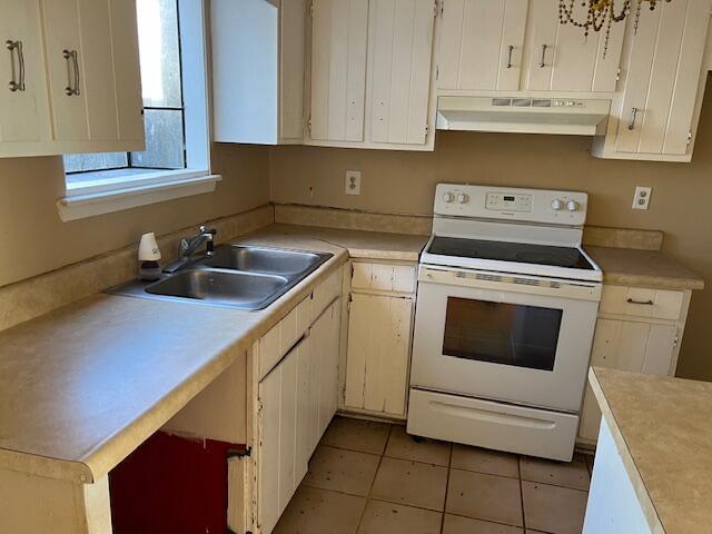 kitchen with sink, white electric range, and light tile patterned floors