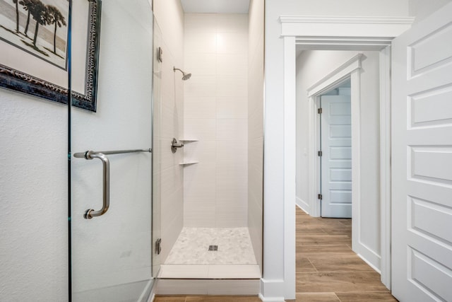 bathroom with wood-type flooring and an enclosed shower