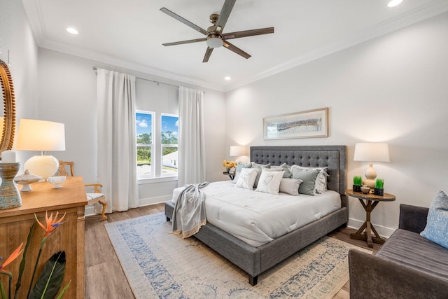 bedroom with hardwood / wood-style flooring, ornamental molding, and ceiling fan