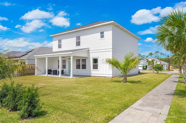 rear view of house featuring a yard and a patio area