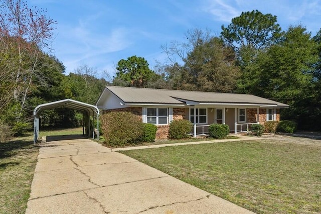 ranch-style house with brick siding, covered porch, a front yard, a carport, and driveway