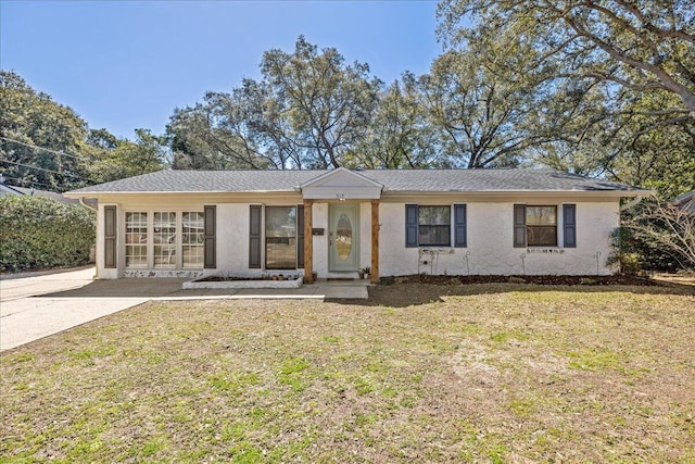 ranch-style home featuring a front yard and stucco siding