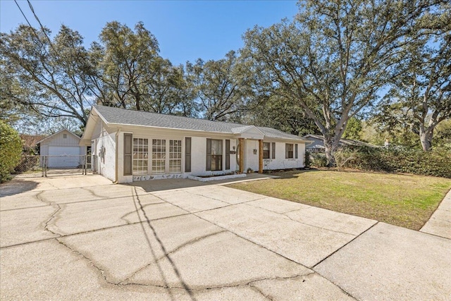 single story home with stucco siding, fence, an outdoor structure, driveway, and a front lawn