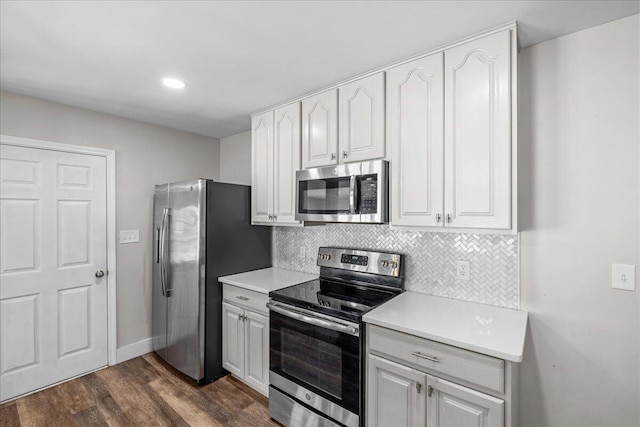 kitchen featuring dark wood-style floors, stainless steel appliances, tasteful backsplash, and light countertops