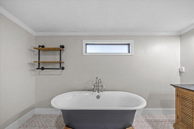 full bath featuring a freestanding bath, baseboards, vanity, and crown molding