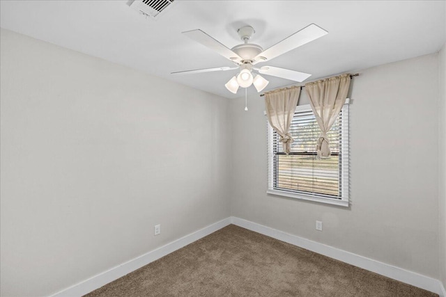 carpeted spare room featuring baseboards, visible vents, and ceiling fan