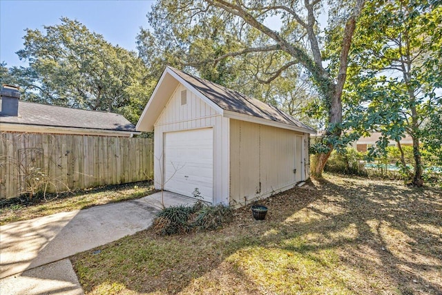 detached garage with driveway and fence