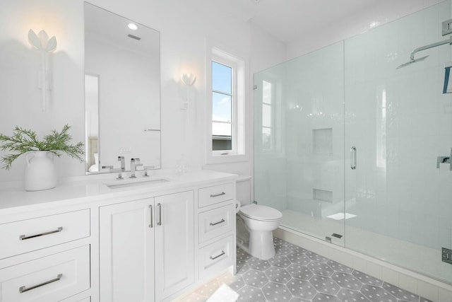 bathroom featuring vanity, toilet, and a shower with shower door