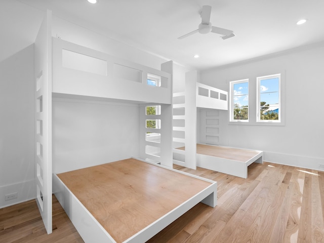 unfurnished bedroom featuring multiple windows, ceiling fan, and light hardwood / wood-style flooring