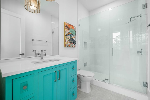 bathroom with tile patterned flooring, vanity, walk in shower, and toilet