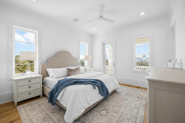 bedroom featuring multiple windows, light wood-type flooring, and ceiling fan