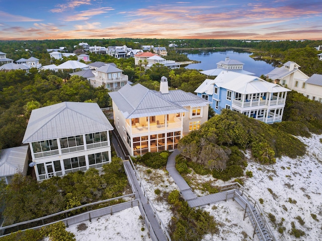 aerial view at dusk featuring a water view