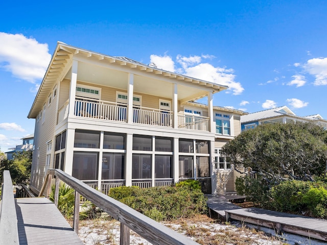 back of house featuring a balcony and a sunroom